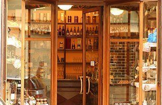 A store front with a glass door and shelves filled with bottles of wine