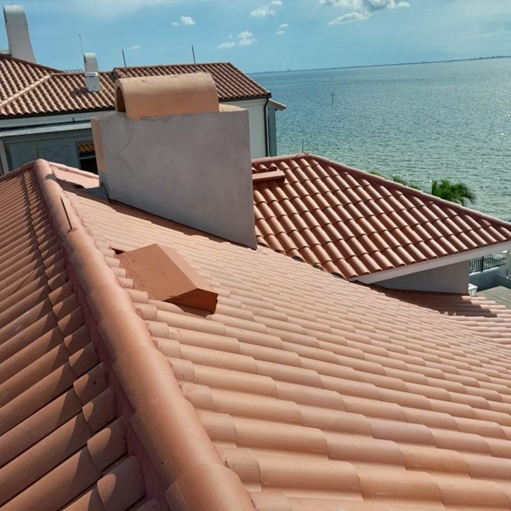 A tiled roof with a chimney on top of it overlooking the ocean — Tampa, FL — Bill Shields Roofing