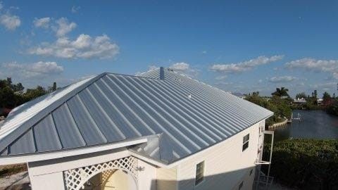 An aerial view of a house with a metal roof and a river in the background — Tampa, FL — Bill Shields Roofing