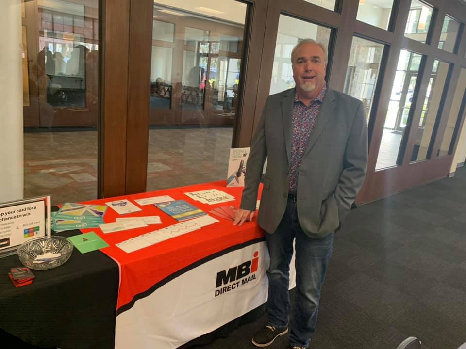 man standing at a table for an event
