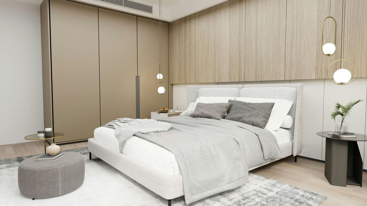 A bedroom with a bed , nightstand , table and ottoman.