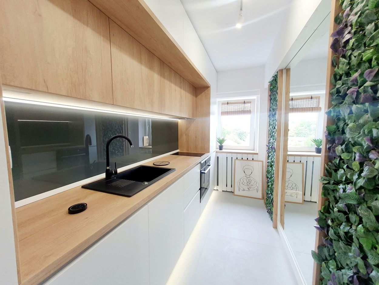 A kitchen with a sink and a mirror.