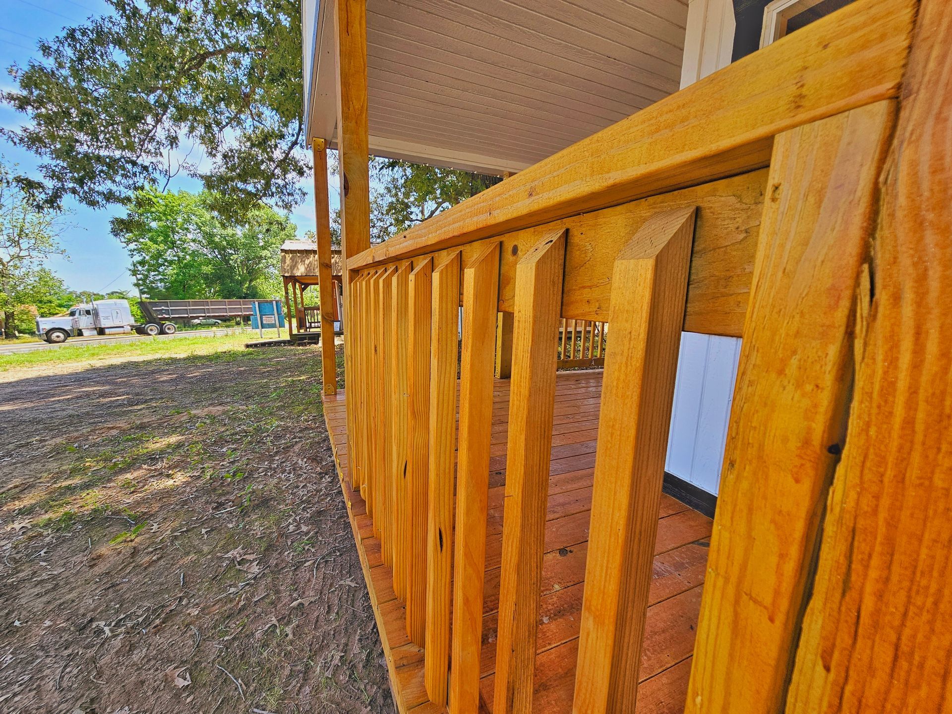 A close up of a wooden railing on a porch.