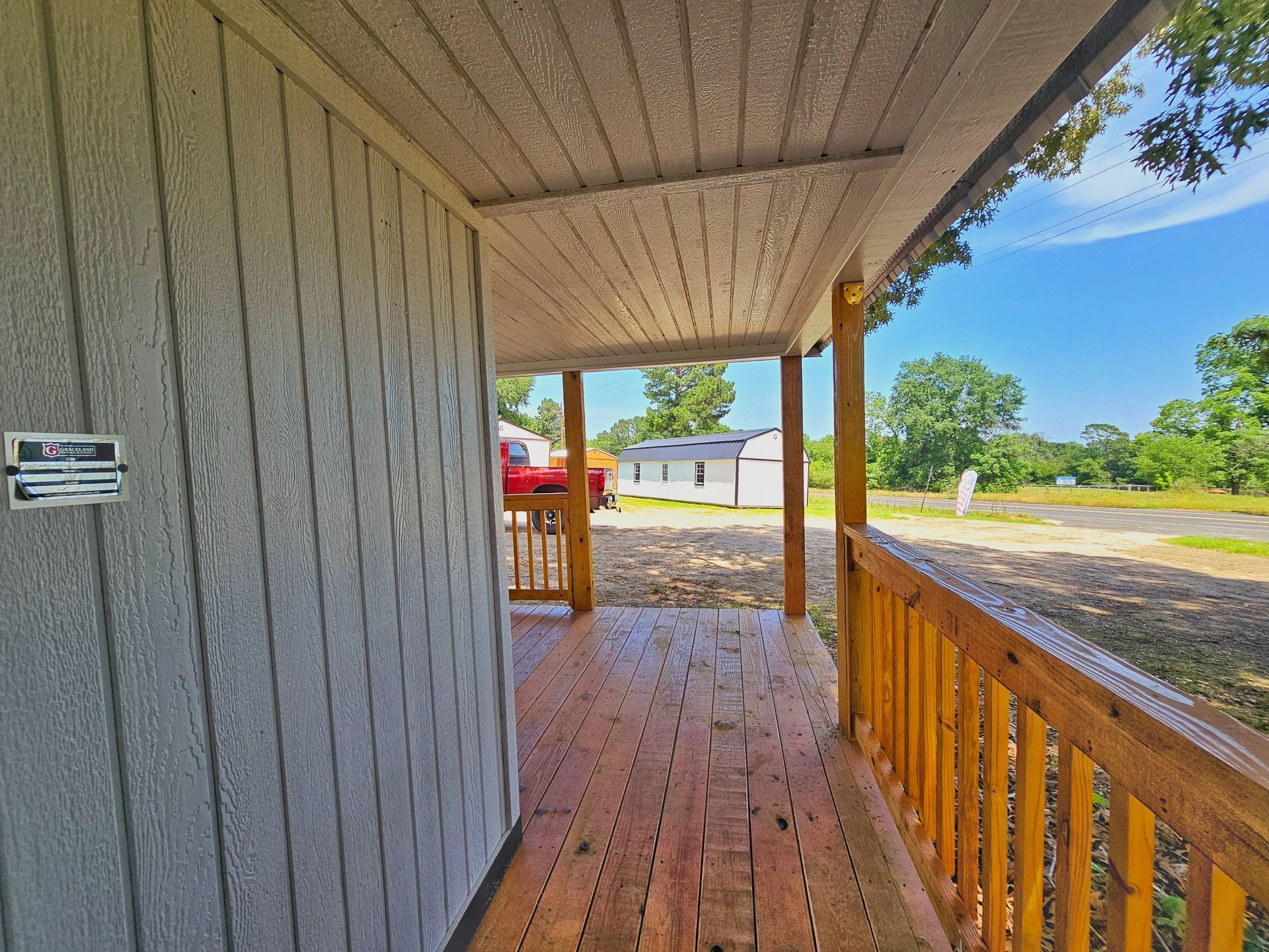 A porch with a wooden railing and a sign that says ' a ' on it