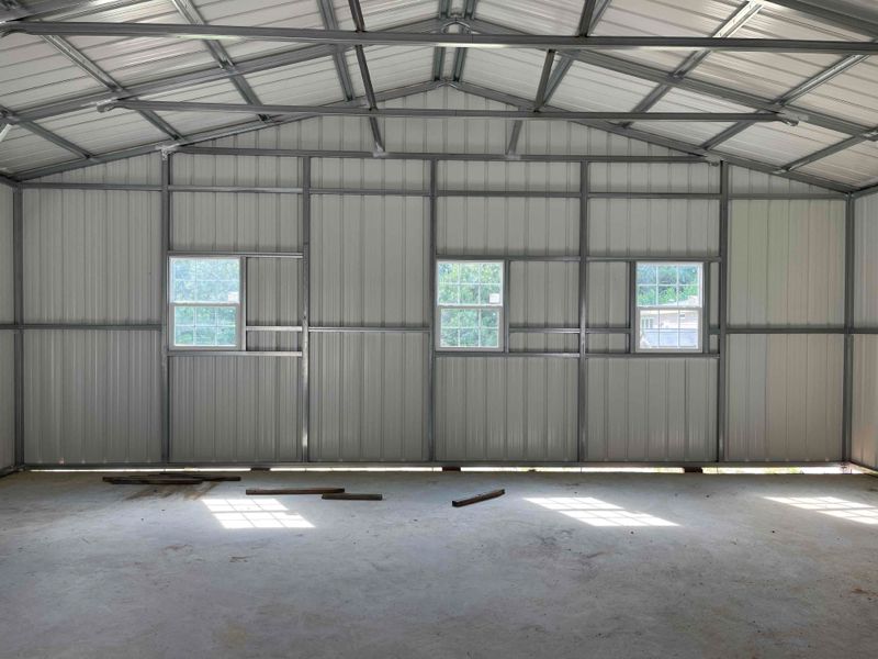The inside of a metal building with a lot of windows.
