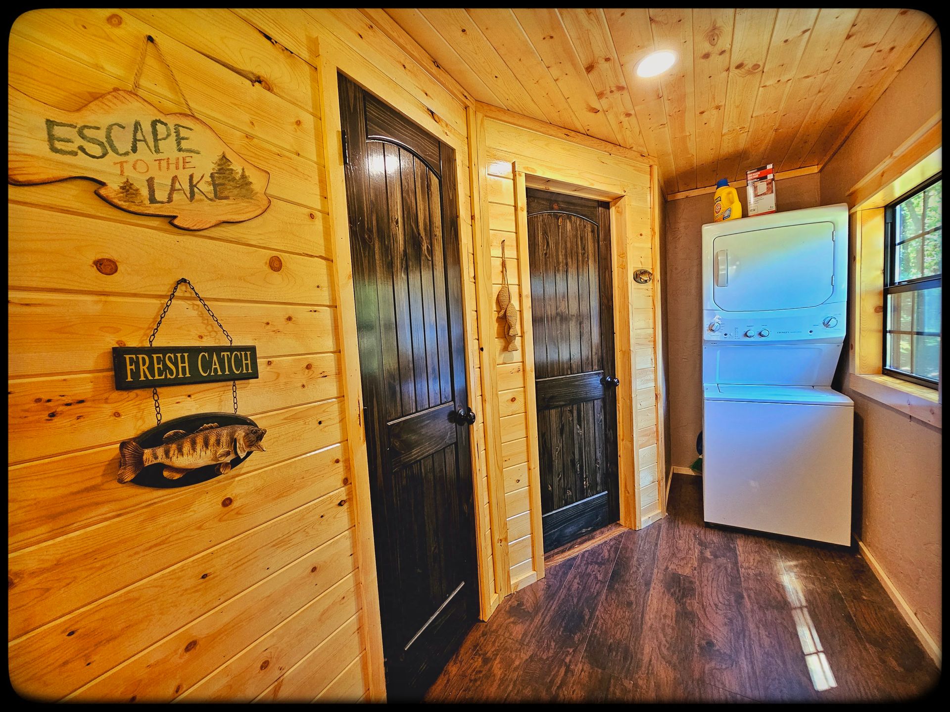 A hallway in a cabin with a washer and dryer.