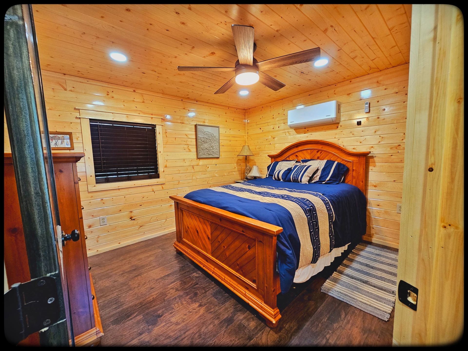 A bedroom with a king size bed and a ceiling fan.