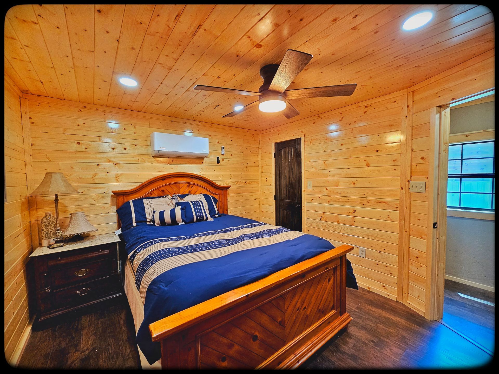 A bedroom with a king size bed and a ceiling fan.