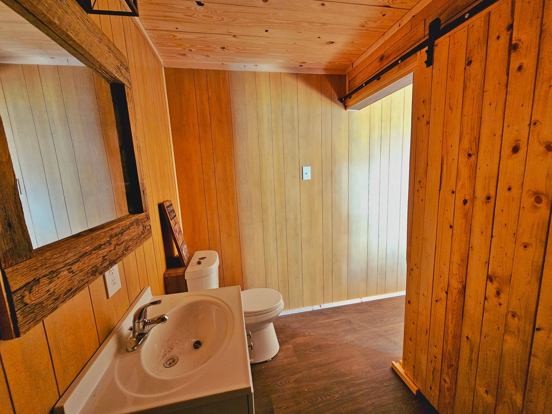 A bathroom with a sink a toilet and a mirror