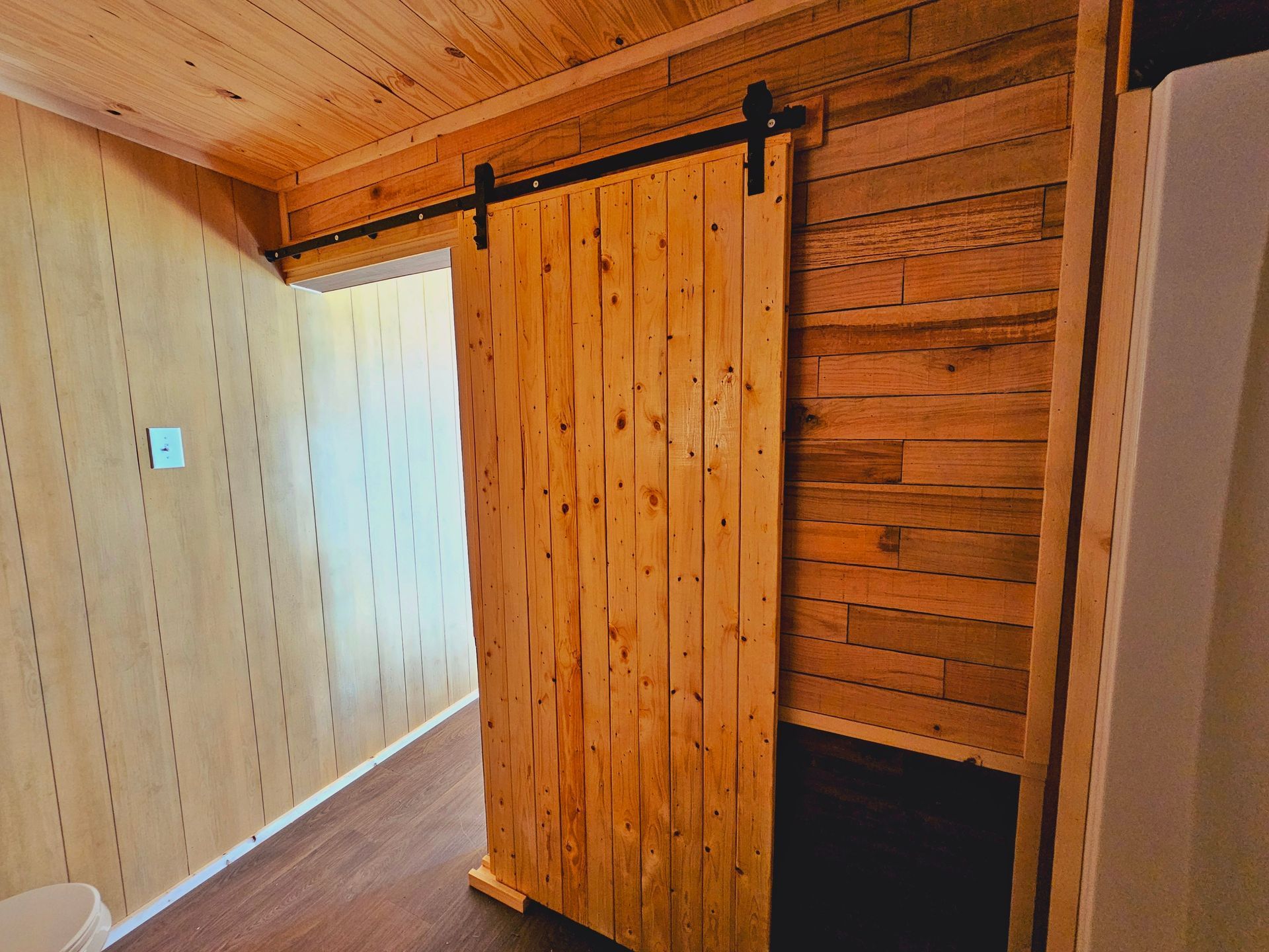 A wooden sliding barn door in a room