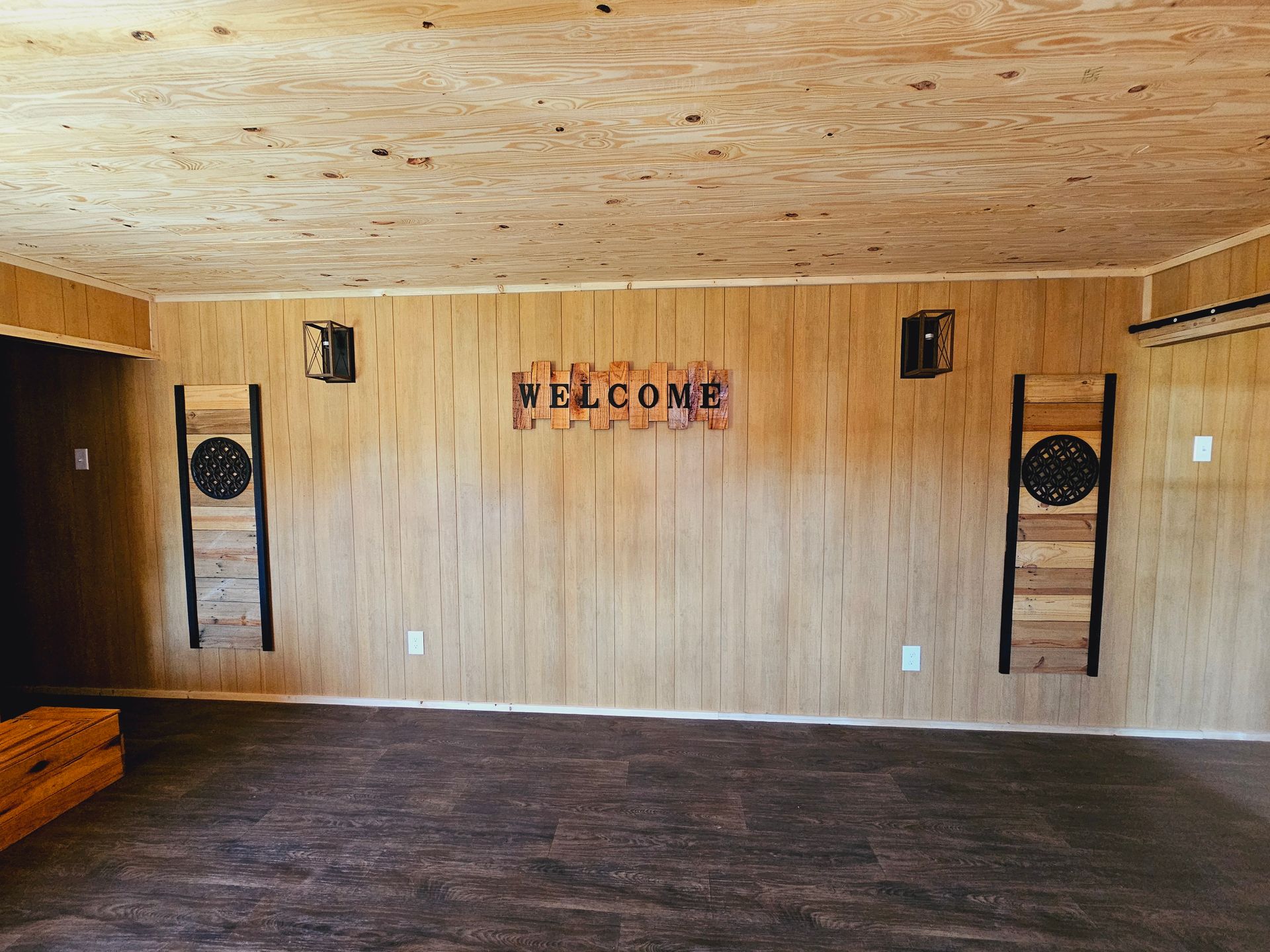 An empty room with a welcome sign on the wall.