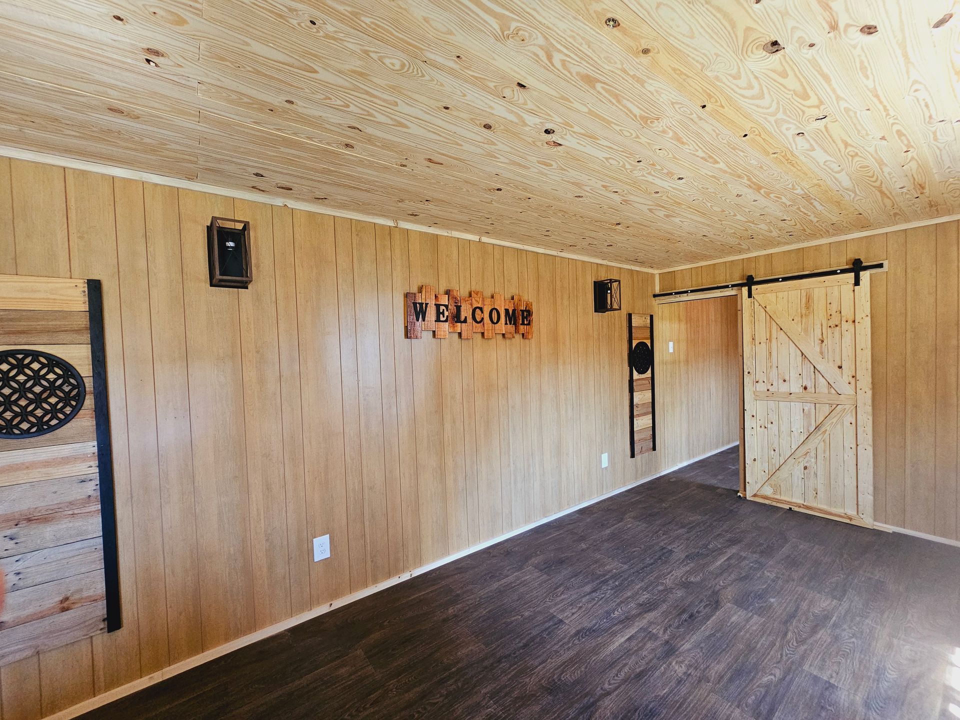 A room with wooden walls and a sliding barn door.