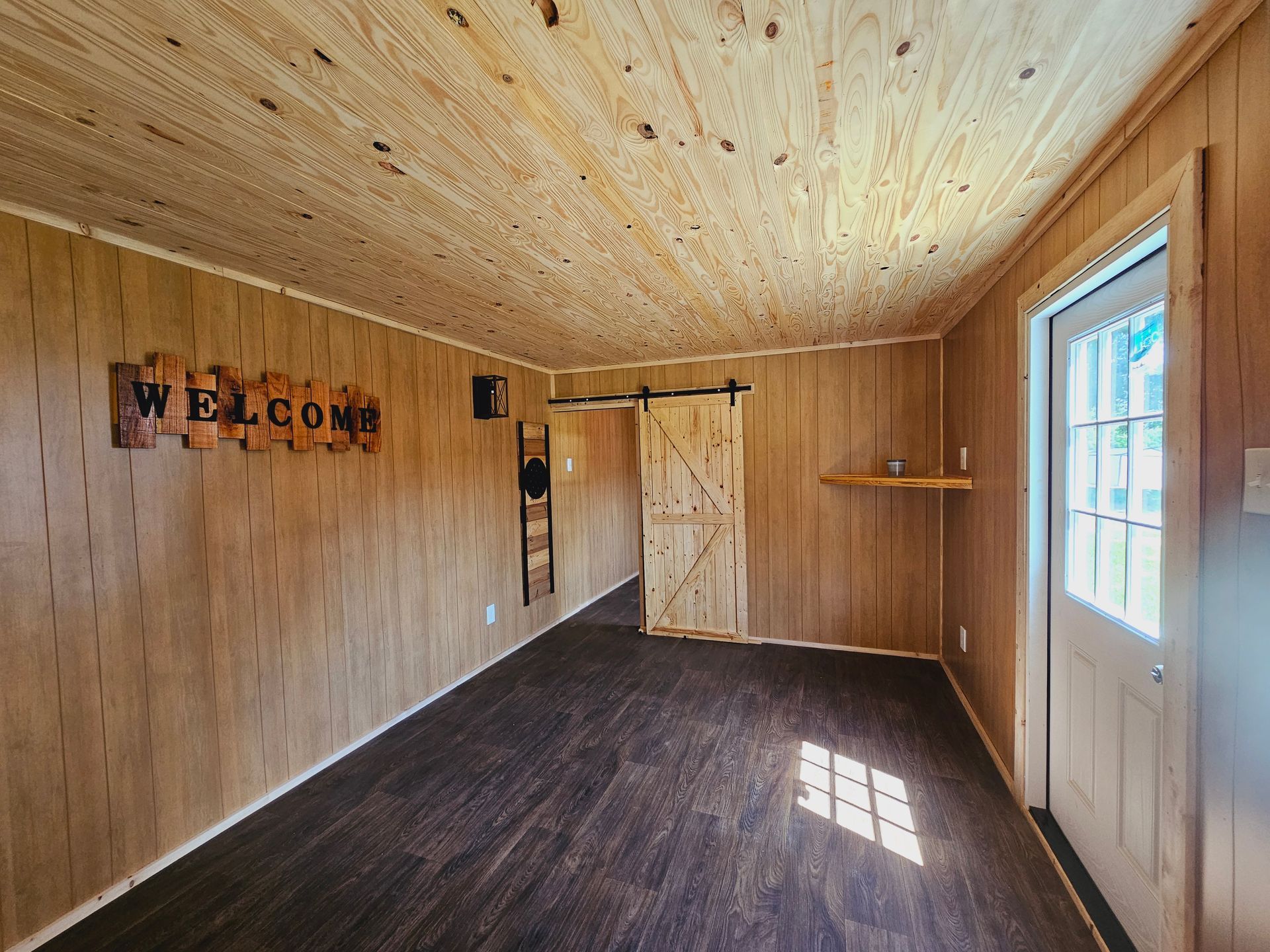 A room with a sliding barn door and a welcome sign on the wall.