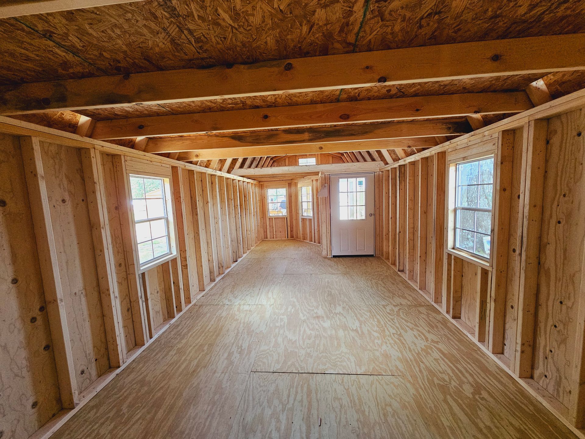 A long hallway with wooden walls and windows under construction