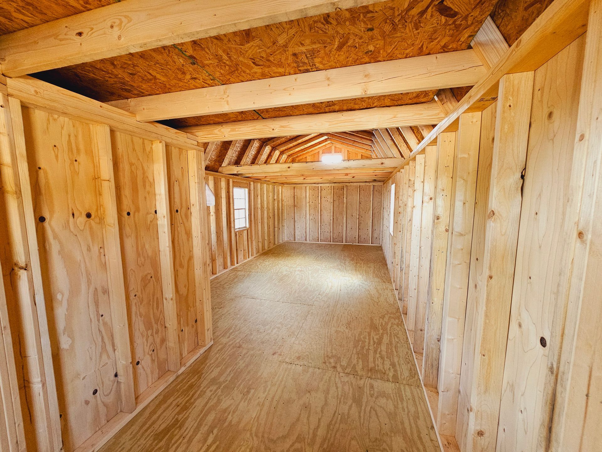 A long wooden hallway in a building under construction.