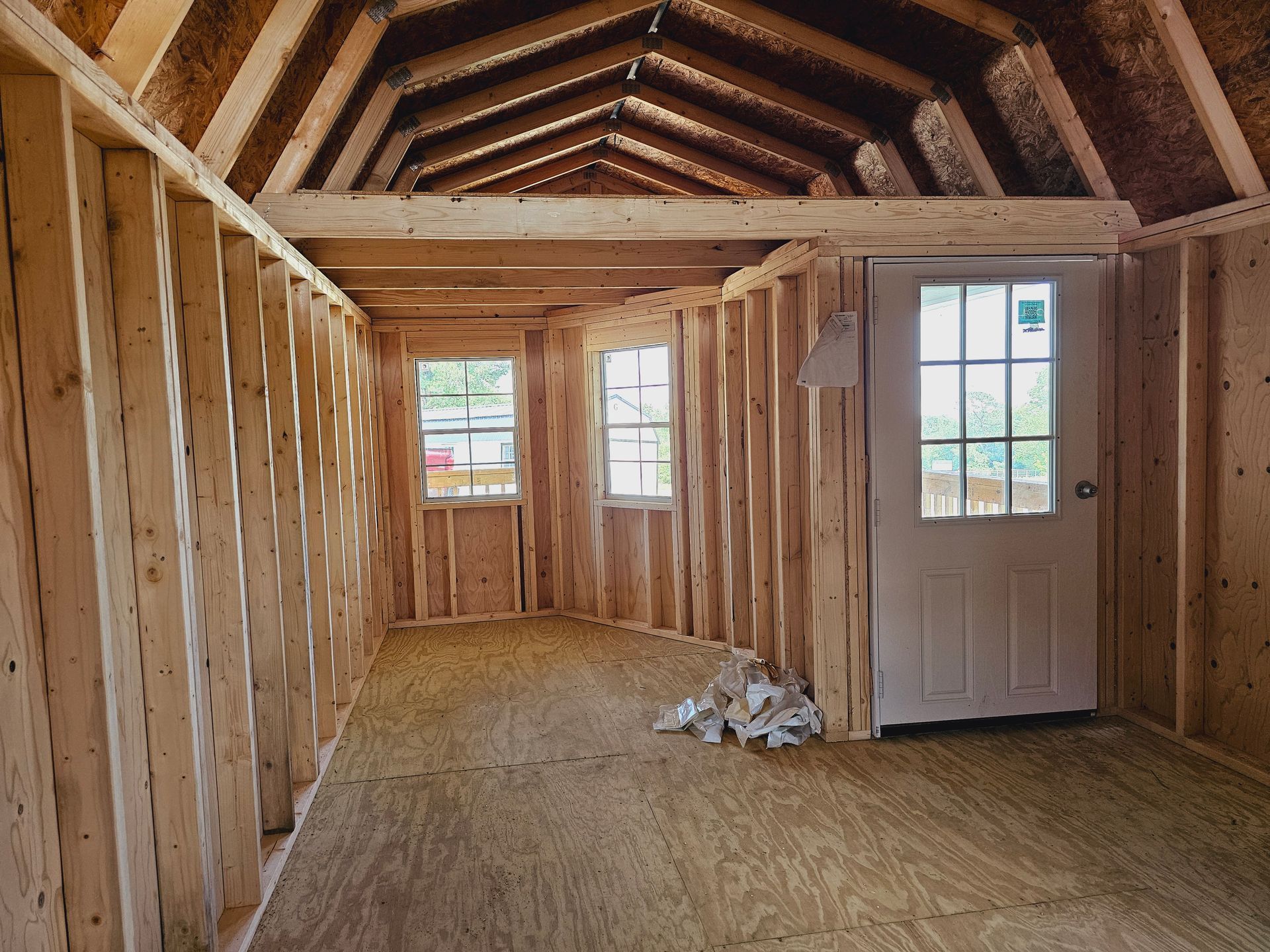 An empty room with wooden walls and a white door