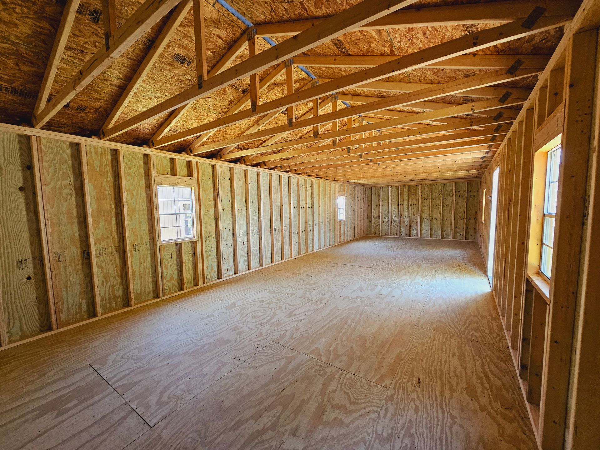 An empty room with wooden walls and a wooden floor under construction.