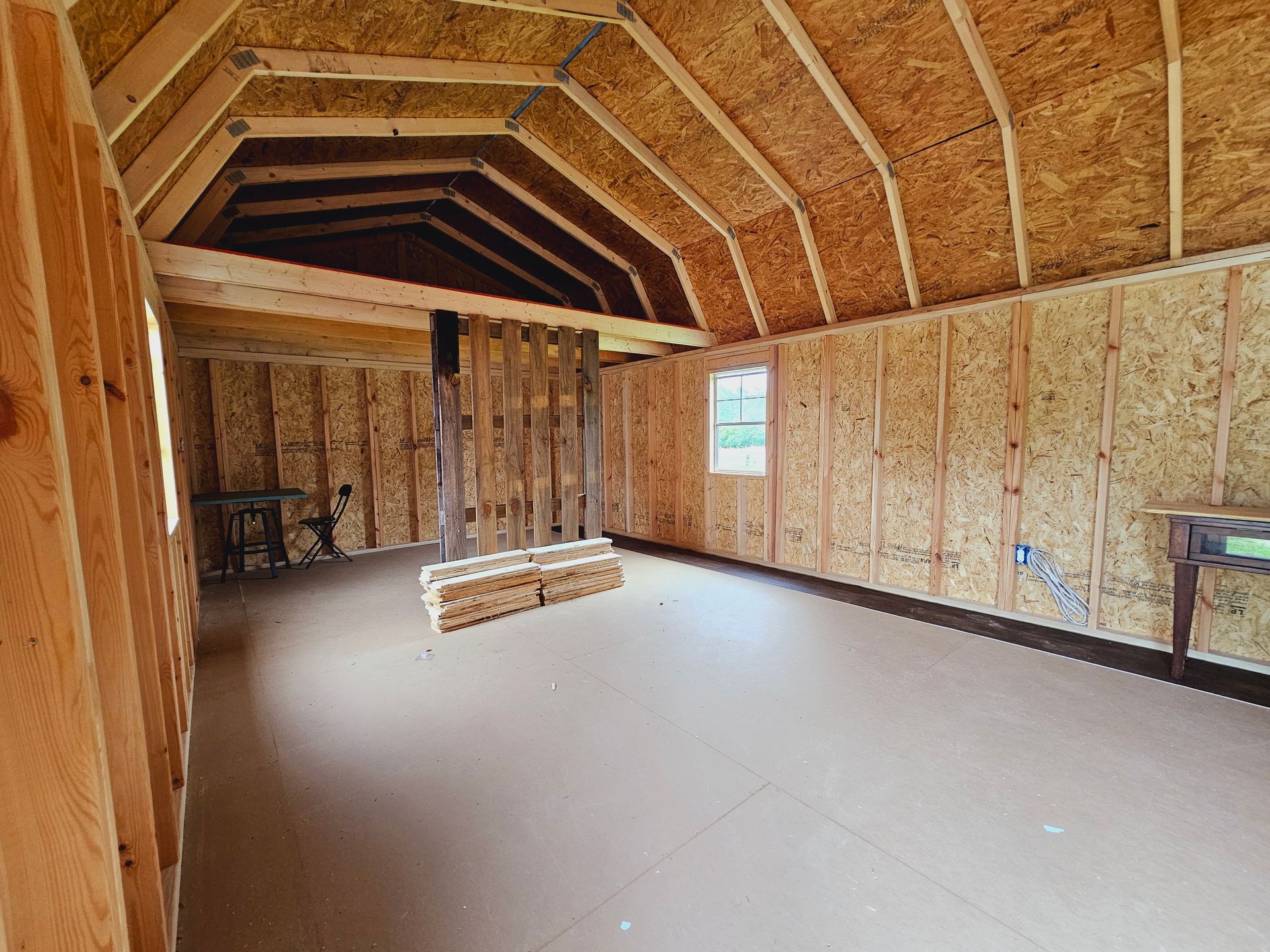 A large empty room with wooden walls and a wooden ceiling.
