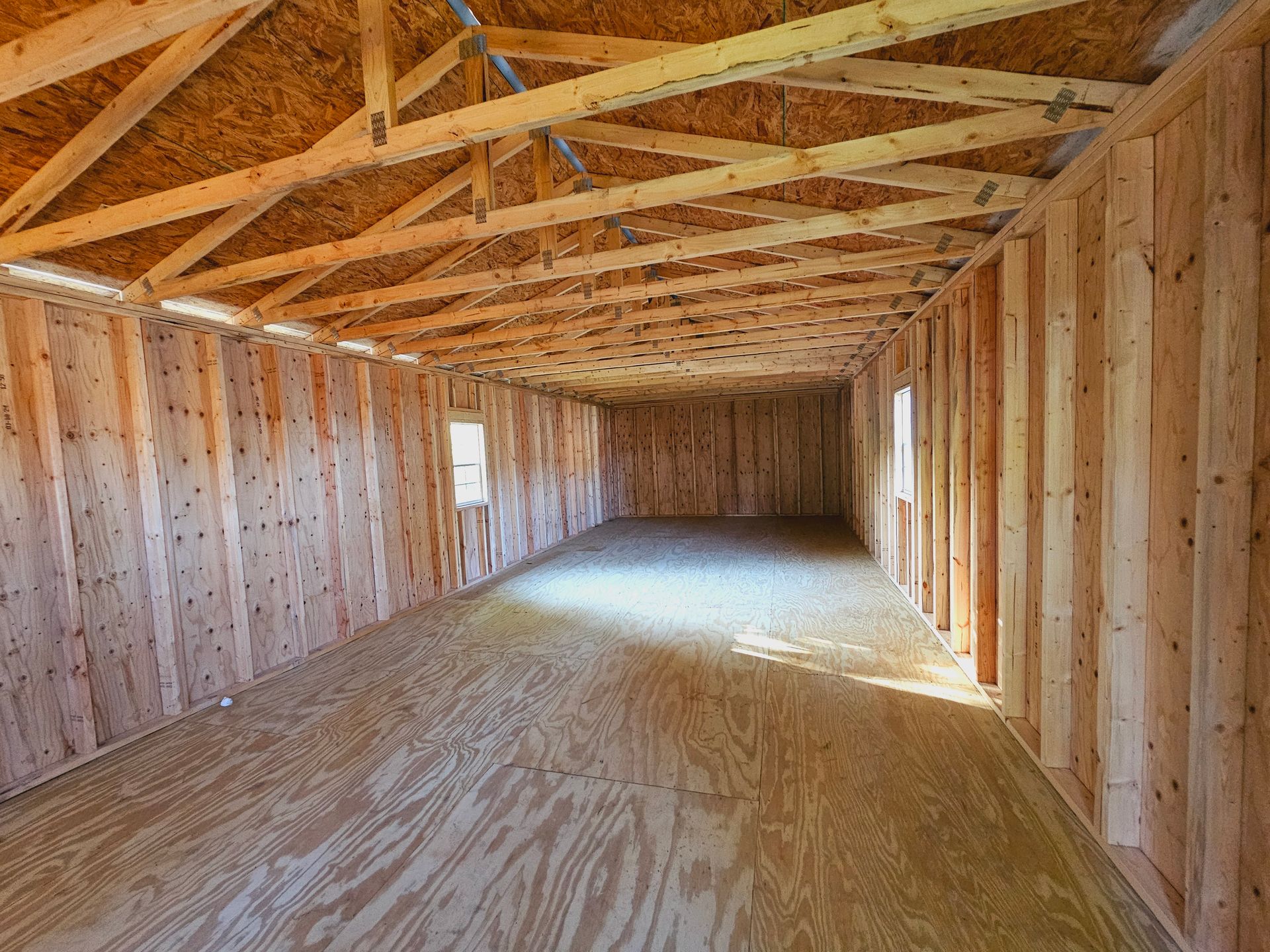 A large empty room with wooden walls and a wooden floor.