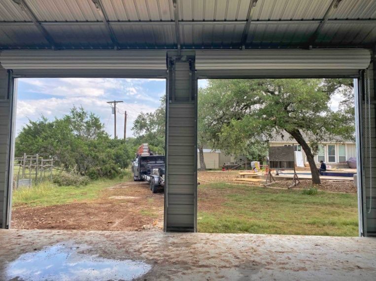 A garage door is open and a truck is parked in the driveway.