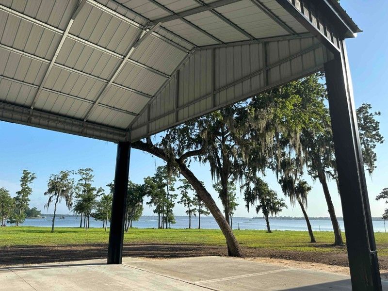 A covered area with trees and a lake in the background