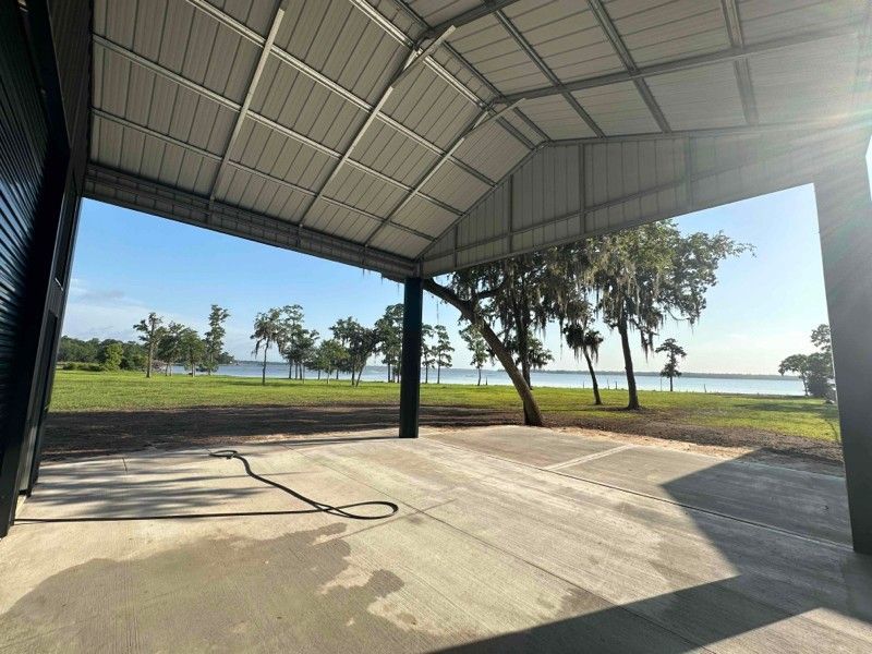 A covered area with a view of a lake and trees