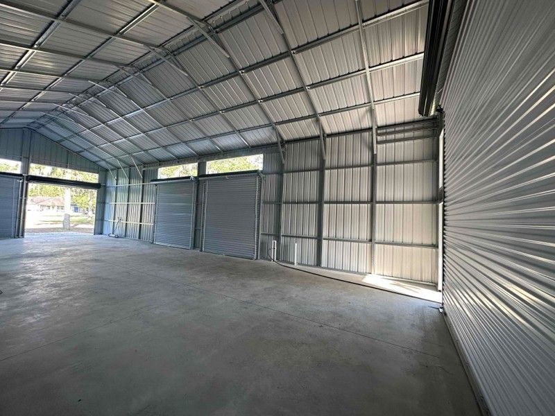 A large empty warehouse with a lot of doors and windows.