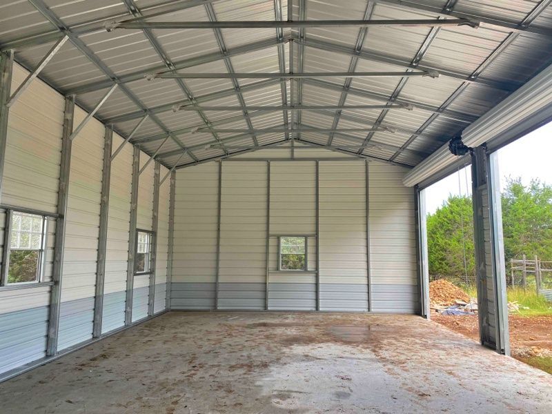 The inside of a metal garage with a roll up door.