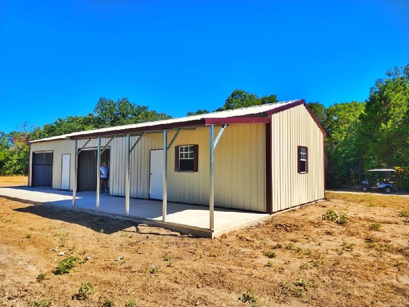 A large metal building with a porch and a golf cart parked in front of it.