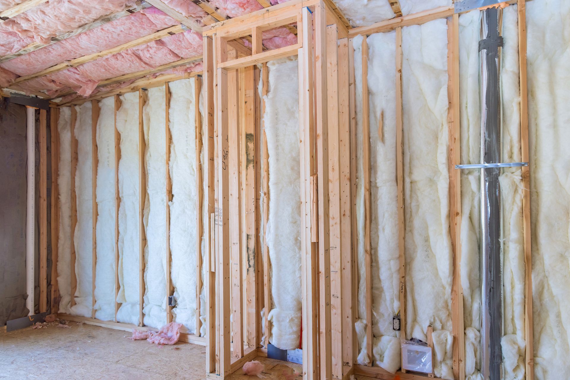 A room in a house under construction with insulation on the walls.