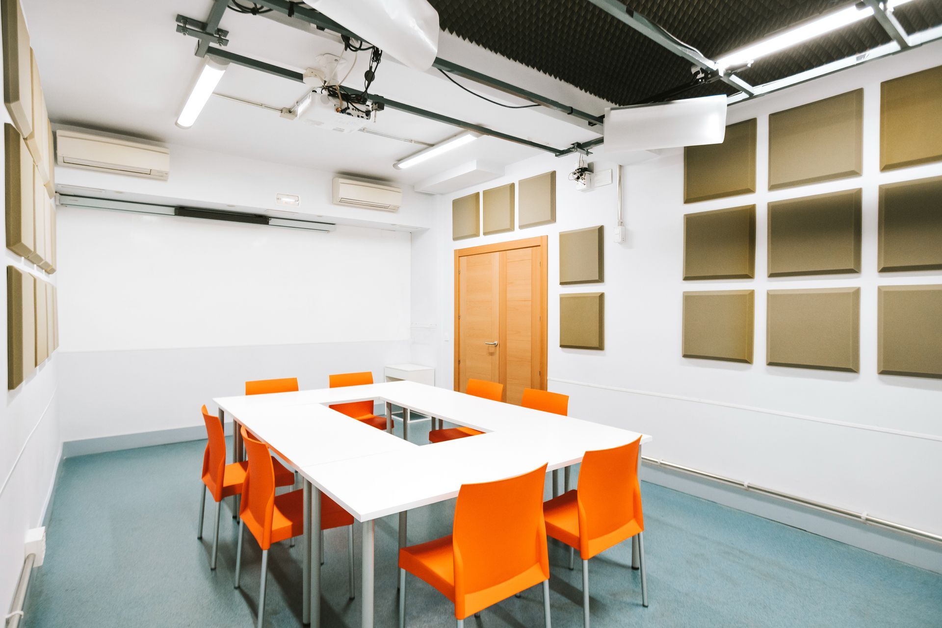 A conference room with a long table and orange chairs