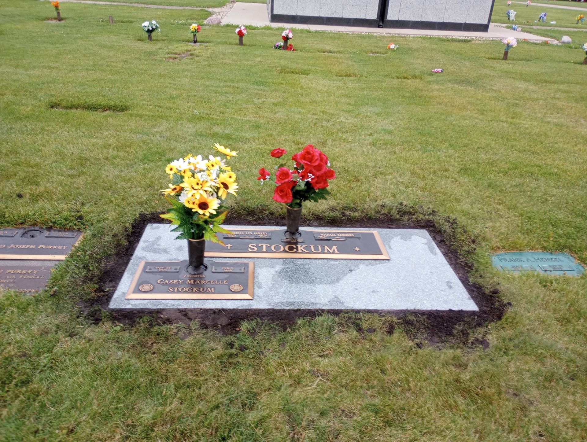 Granite Bronze with yellow and red flowers in a grassy cemetery Pontiac, IL