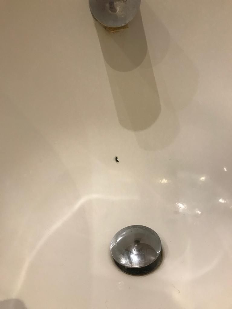 A close up of a bathroom sink with a drain and a faucet.