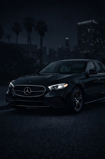 Black Mercedes-Benz sedan with a silver grill and wheels, angled slightly to the left.
