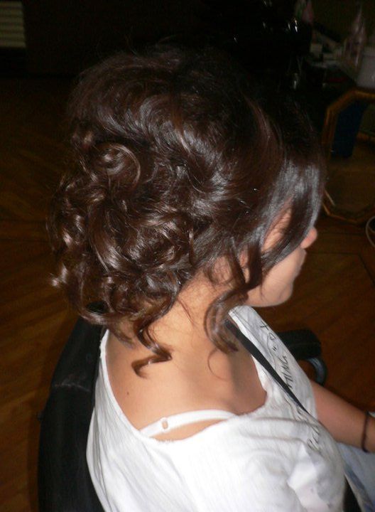 Woman With Dark Curly Updo, Wearing a White Top, Seated — Lavish Hair in Shepparton, VIC