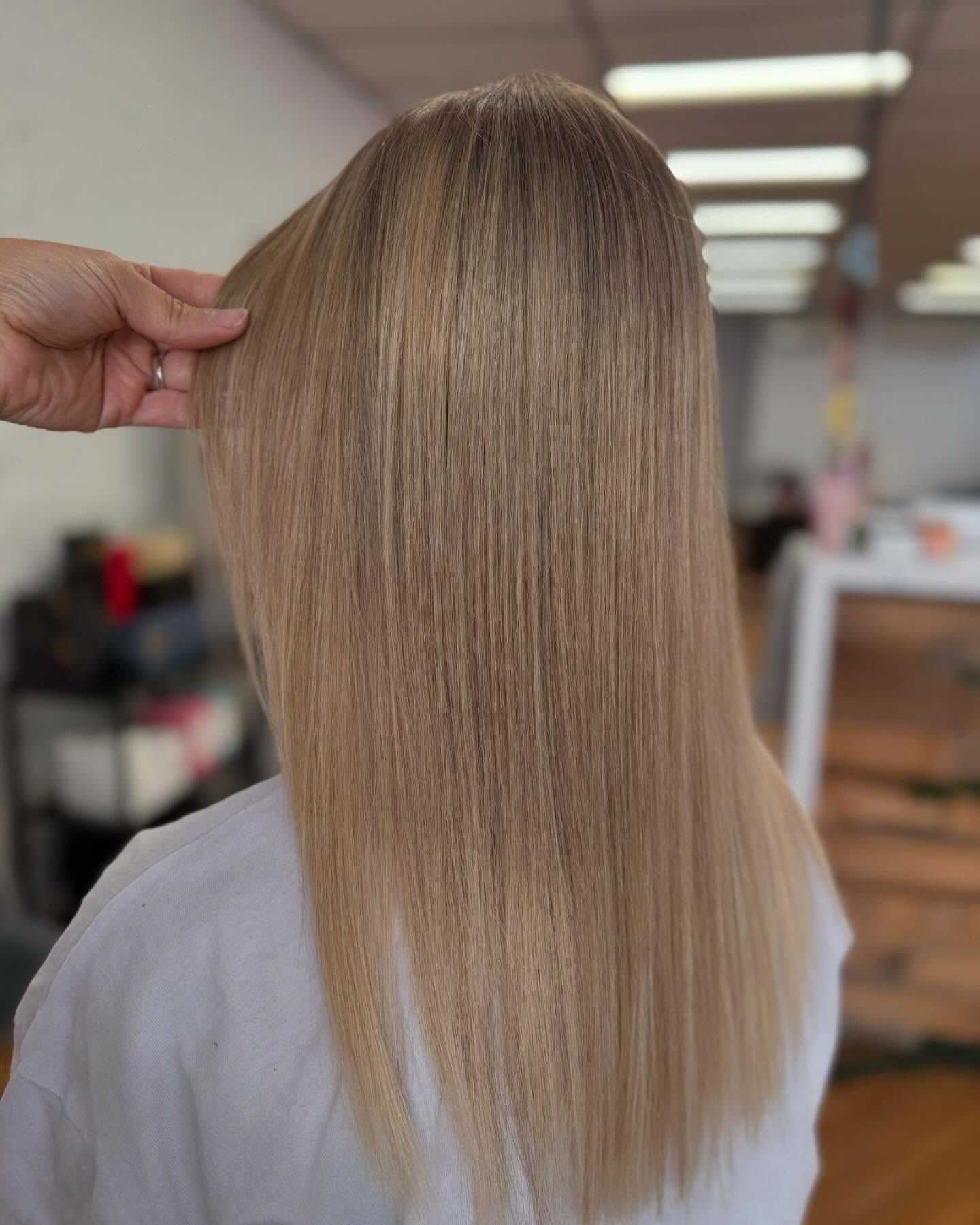 Blonde Hair Styled Straight, Hand Touches Strands — Lavish Hair in Shepparton, VIC