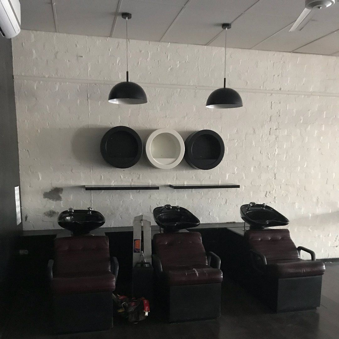 Hair Salon Interior With Black and Brown Chairs, Basins, and Pendant Lights — Lavish Hair in Shepparton, VIC