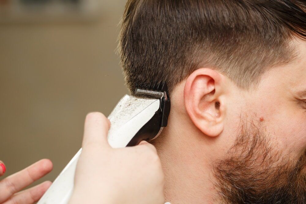 Person Getting a Haircut With Clippers Near the Ear — Lavish Hair in Shepparton, VIC