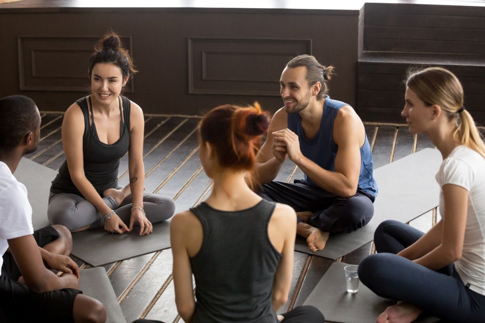 A Group Of People Are Sitting In A Circle On Yoga Mats — Wegner Therapies In Pialba, QLD