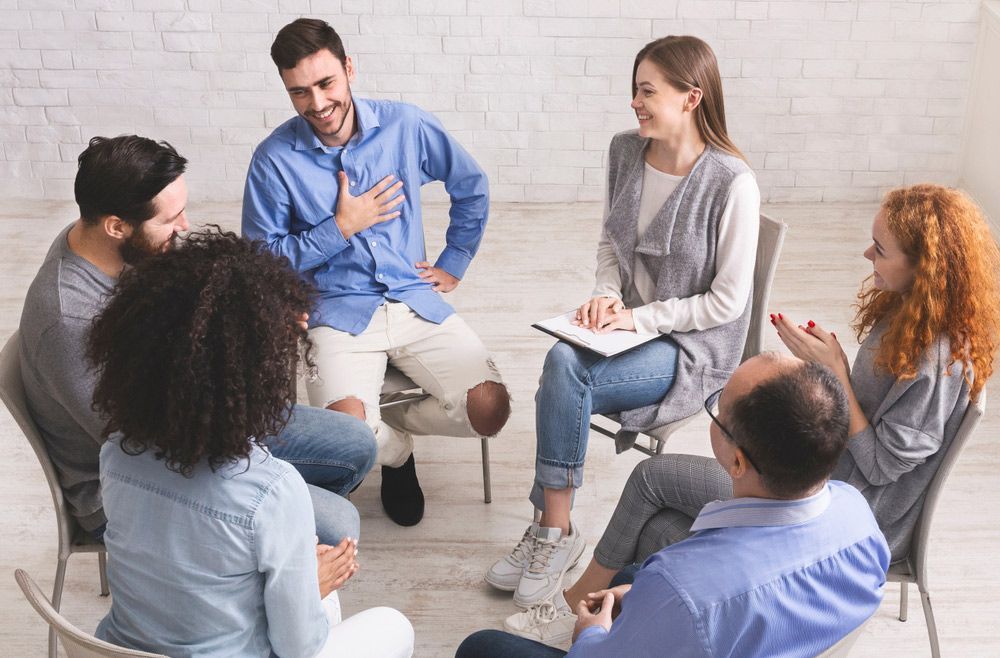 A Group Of People Are Sitting In A Circle Talking To Each Other — Wegner Therapies In Pialba, QLD