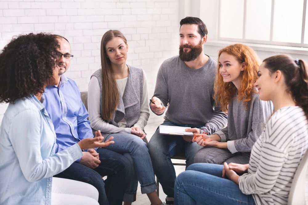 A Group Of People Are Sitting In A Circle Talking To Each Other — Wegner Therapies In Pialba, QLD