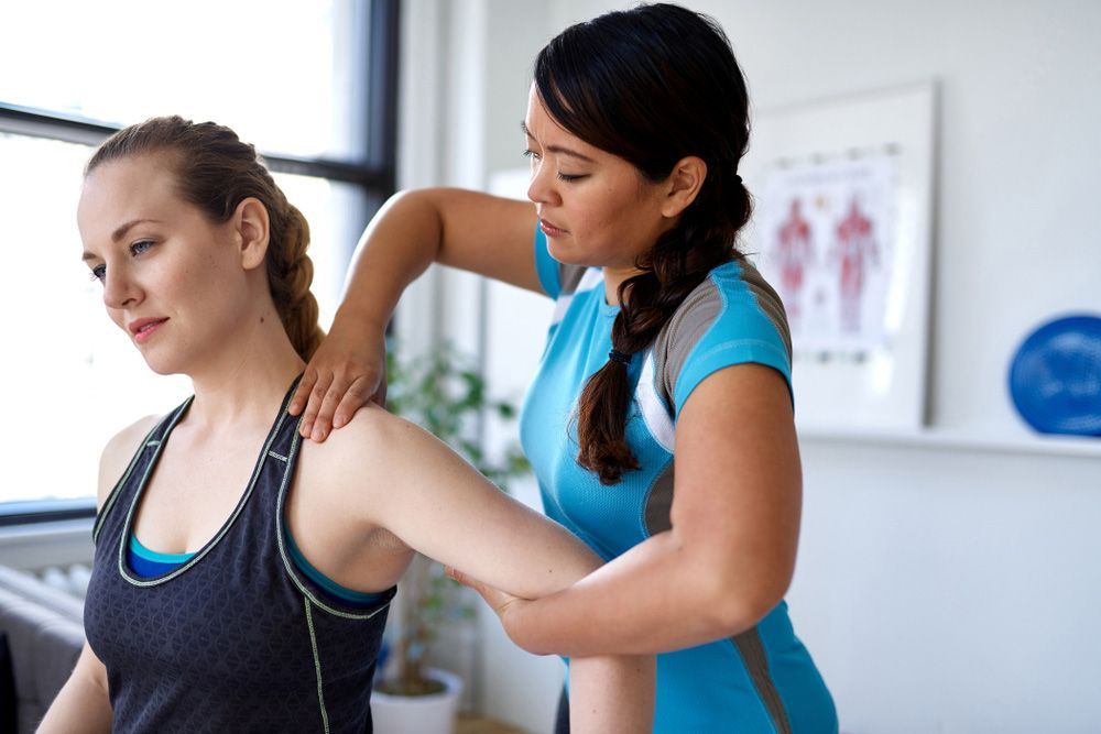 A Woman Is Getting A Massage From A Female Physical Therapist — Wegner Therapies In Pialba, QLD