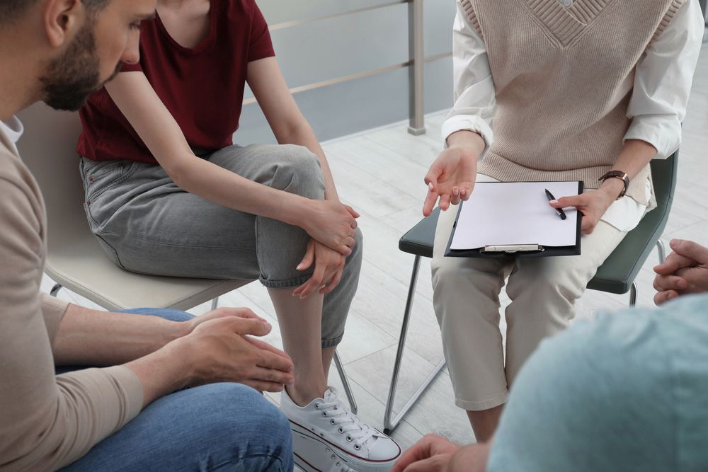A Group Of People Are Sitting In A Circle Talking To Each Other — Wegner Therapies In Pialba, QLD