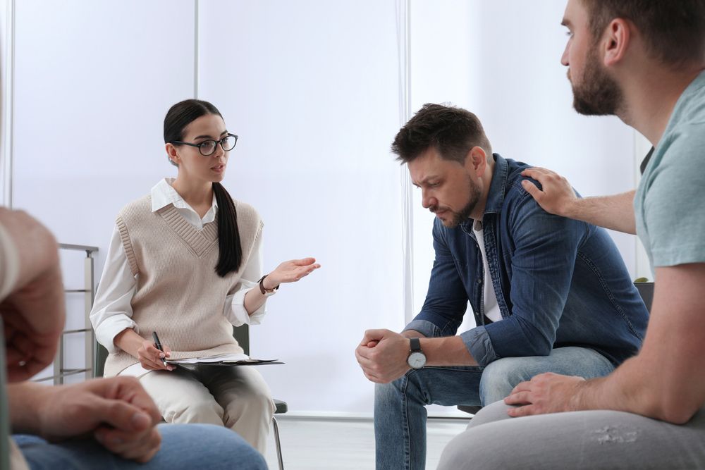 A Group Of People Are Sitting In A Circle Talking To Each Other — Wegner Therapies In Pialba, QLD
