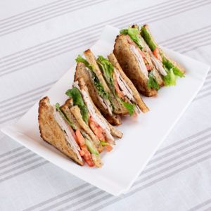 A white plate topped with sandwiches on a table
