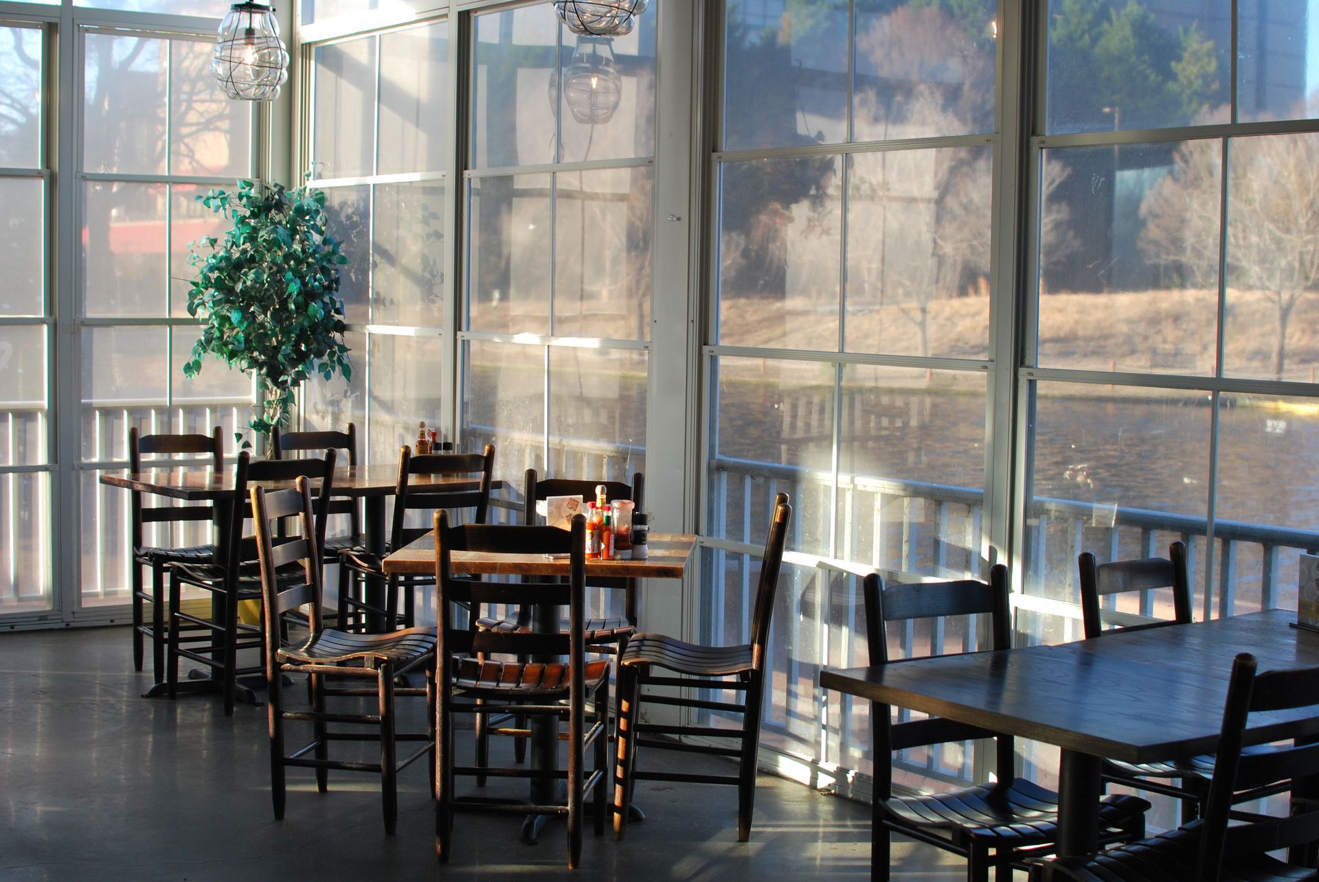 A restaurant with tables and chairs in front of a screened in porch