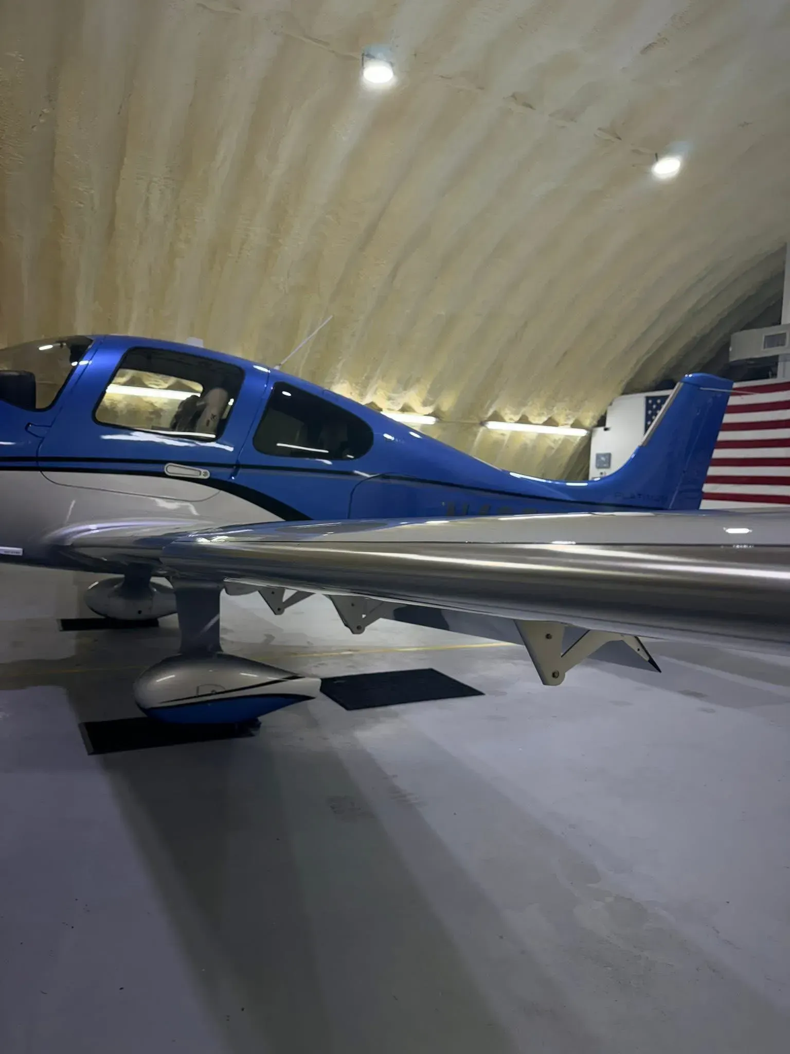 Blue and silver airplane parked inside a hangar.