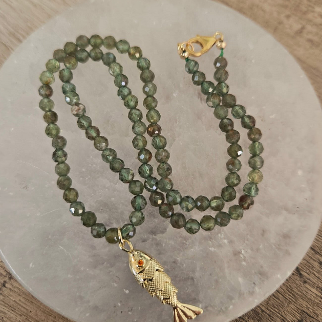 Gold fish pendant necklace with green faceted beads.