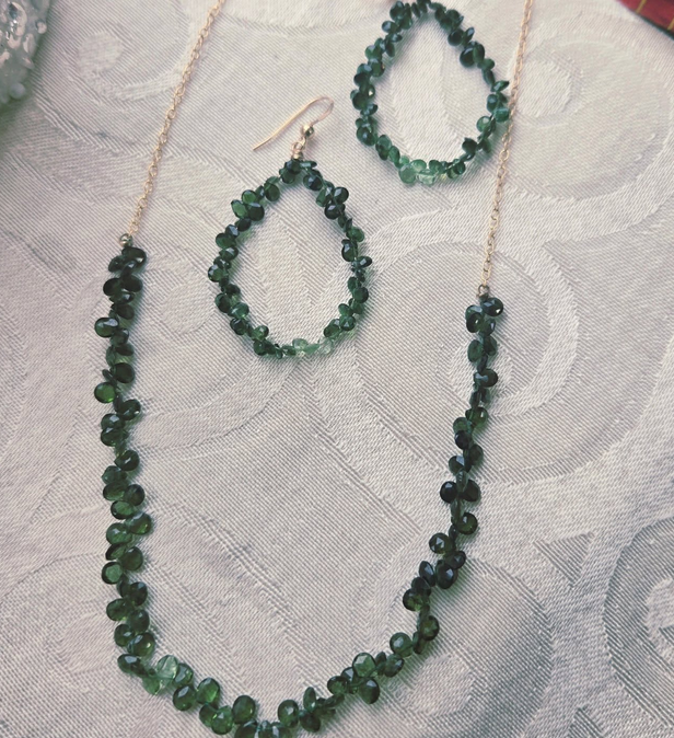 Green beaded jewelry set: necklace and earrings, on a white surface.