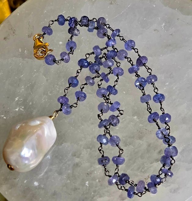 Necklace with blue beads and a large white baroque pearl.